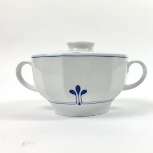 Op de afbeelding: Witte porseleinen soepterrine met een blauw bloemenmotief en een deksel. De soepterrine heeft twee handvatten en een afgeronde vorm.