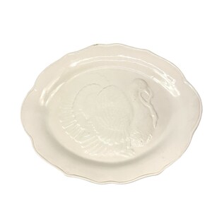 Puede incluir: Plato de servir ovalado de cerámica blanca con un diseño en relieve de un pavo.