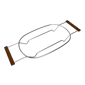 Puede incluir: Una bandeja de baño de metal plateado con asas de madera. La bandeja tiene forma ovalada y está diseñada para colocarse a lo ancho de una bañera. Las asas de madera son rectangulares.