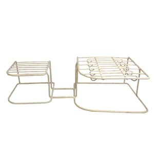 May include: Off-white metal plant stand with two tiered platforms connected by a central support. The platforms have a grid-like design, and the stand has a square base. The stand is suitable for displaying multiple plants.