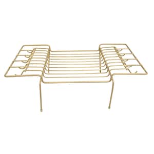May include: A vintage, light gold-colored metal dish rack. The rack has a rectangular shape with a series of parallel bars for holding dishes. It features side extensions with curved edges and is supported by four legs.