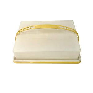 Peut inclure: Un récipient de conservation alimentaire rectangulaire blanc avec une base jaune et une poignée arquée jaune assortie. Le récipient présente un couvercle opaque lisse et un plateau inférieur jaune plat et solide pour transporter des aliments.