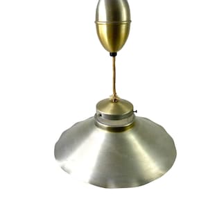 May include: A vintage pendant light with a silver metal shade and a gold metal pull chain. The shade has a scalloped edge and a clear glass diffuser.