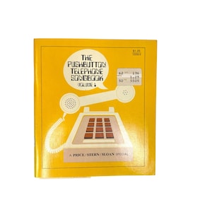 May include: A vintage yellow book titled "The Pushbutton Telephone Songbook Volume 1." The cover features a white illustration of a push-button telephone with a handset and the text "A Price/Stern/Sloan Special."