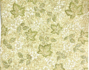 May include: A fabric featuring a repeating pattern of green leaves and white flowers on a light beige backdrop. The leaves are of varying sizes and are detailed with veins, creating a natural, botanical theme.