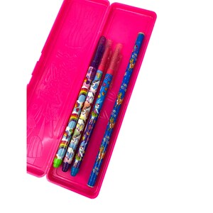 May include: A bright pink pencil case with a hinged lid, open to reveal four pens. The pens have colorful designs featuring unicorns, rainbows, and other whimsical elements. The pens are blue, purple, and red.