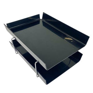 May include: A two-tier document tray featuring glossy black rectangular plastic shelves stacked vertically. The trays are held together by thin, silver-colored metal wire supports that connect the upper and lower levels on each side.