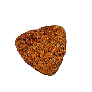 May include: A triangular amber glass dish with a textured surface. The dish has a unique, organic shape and a rich, warm color.