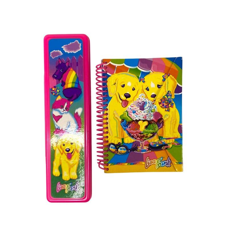 May include: A pink pencil case and spiral notebook featuring Lisa Frank designs. The pencil case has illustrations of dogs and a fox. The notebook has two yellow dogs with ice cream. The Lisa Frank logo is visible on both items.