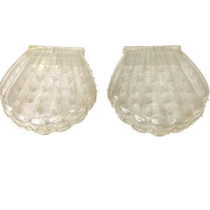 May include: Two clear plastic clam shell shaped boxes with a beaded edge.
