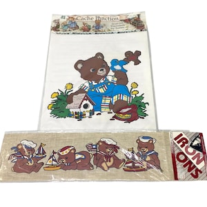 May include: Iron-on transfers featuring cartoon bears. One design shows a bear in overalls with a birdhouse and bird. Another design shows bears in sailor hats with sailboats and flags. The top transfer is labeled "Cache Junction".