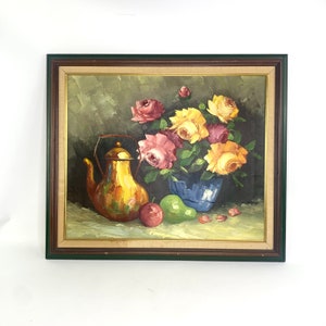 May include: A framed oil painting depicting a still life with a copper teapot, a blue vase filled with a bouquet of colourful roses, and fruit. The painting has a dark green background.