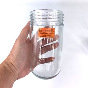 May include: A clear glass light fixture with a UL label that reads "E-15896 MAX UNDERWRITERS LABORATORIES 100 WATTS INCANDESCENT FIXTURE ISSUE NO. 133,681 SUITABLE FOR WET LOCATIONS".