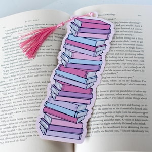 May include: A pink and blue bookmark with a stack of books illustrated on it. The bookmark has a pink tassel. The text on the bookmark reads "I think..." and continues with a quote about marriage and relationships.