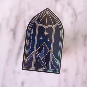 May include: A sticker featuring a stylized window design with a night sky scene. The image includes mountains, stars, and the text "To the stars who listen..." in a gold glitter outline. The sticker has a dark blue and gold color scheme.