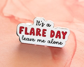 May include: White enamel pin with red glitter lettering that reads "It's a flare day leave me alone".
