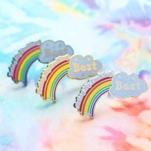 May include: Three rainbow enamel pins with a cloud and the text "Doing my fucking best" in gold lettering.