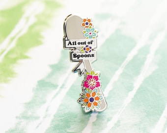 May include: Silver spoon enamel pin with a floral design and the text "All out of Spoons".