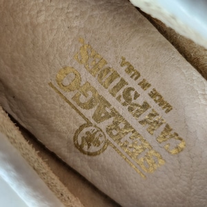 Puede incluir: Primer plano del interior de un zapato de cuero blanco con las palabras "GRASSLANDS" y "Made in USA" en letras doradas.