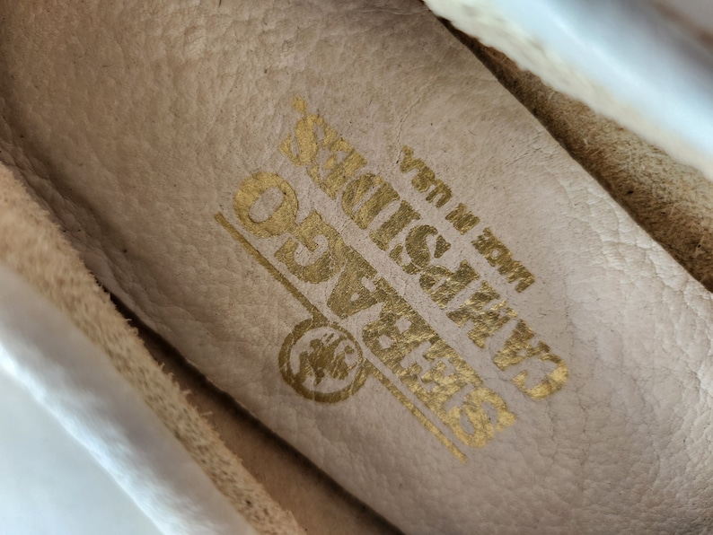 Puede incluir: Primer plano del interior de un zapato de cuero blanco con las palabras "GRASSLANDS" y "Made in USA" en letras doradas.