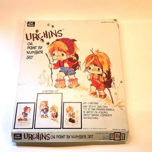 May include: A Craft Master oil paint by number set featuring three pictures of cartoon characters called "Urchins". The set includes two 7x10 inch pre-printed panels, one 10x14 inch pre-printed panel, 18 artist oil colors, an artist brush, and complete instructions.