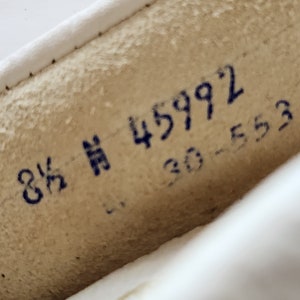 Puede incluir: Primer plano de un zapato de cuero blanco con marcas de tinta azul. Las marcas dicen "8 1/2" y "45992 30-553".