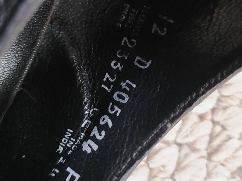 May include: Close-up of the inside of a black leather shoe. The shoe size is 12 D. The shoe is made in India. The style number is 405624.