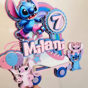 May include: A pink and blue 3D cake topper featuring Stitch and Angel from Lilo & Stitch. Stitch is wearing roller skates and holding a pink and blue balloon. The topper also includes a pink roller skate, a blue and pink rainbow, a pink star, and the number 7. The name "Milani" is written in pink letters.