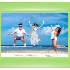 May include: Three friends jump in the air on a beach with a blue sky and white clouds in the background. They are all wearing sunglasses and smiling.