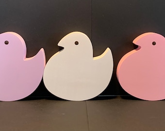 May include: Five wooden chick shaped ornaments in different pastel colors: light blue, pink, white, light pink, and yellow.