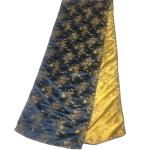 May include: Reversible fabric with a navy blue side featuring a gold dragon pattern and a gold satin side. The fabric is folded, showcasing both sides. The material appears to be silk or a similar luxurious fabric.