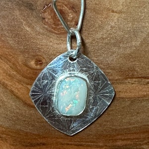 A lovely white Australian opal bezel set on a sterling silver pendant