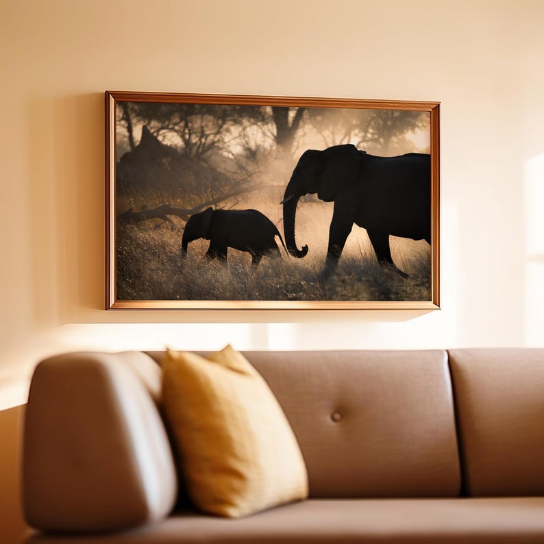 May include: A framed photograph of two elephants walking through tall grass in a hazy, golden light. The larger elephant is in the foreground, while the smaller elephant is following behind.