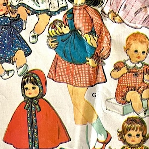 May include: Vintage paper doll cutouts featuring several dolls in various outfits. One doll wears a red cape with a hood, while another holds a doll in a blue carrier. The dolls are dressed in dresses and rompers.