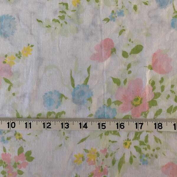 Vintage full sized flat bed sheet in a poly cotton blend, light pink, light blue and yellow floral with green on white background