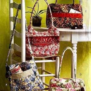 May include: Four quilted fabric handbags labeled A, B, C, and D. Bag A features a blue and yellow floral pattern with a front pocket containing a small book titled SEWING. Bag B is red and white with a floral print. Bag C has a paisley pattern with a red band. Bag D has a pink floral print.