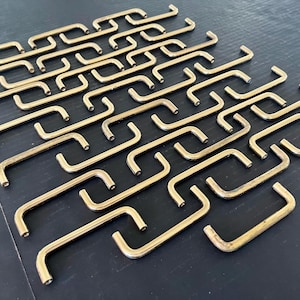 Set van 43 gebruikte goudkleurige metalen ladetrekkers met bevestigingsschroeven, diameter 3,5 inch, allemaal in goede staat, maar moeten goed worden schoongemaakt.