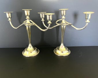 Set of 2 silver plated 3-candle candelabras, each is 10" tall x 11 5/8" wide x 4" deep.