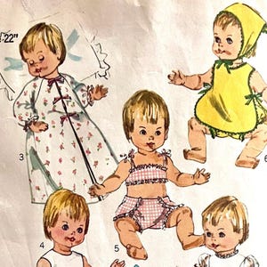 May include: Vintage doll pattern with illustrations of a 56 cm doll in different outfits. The doll is depicted in a floral robe, a yellow bib and bonnet, and pink gingham swimwear. The pattern includes multiple views of the doll.
