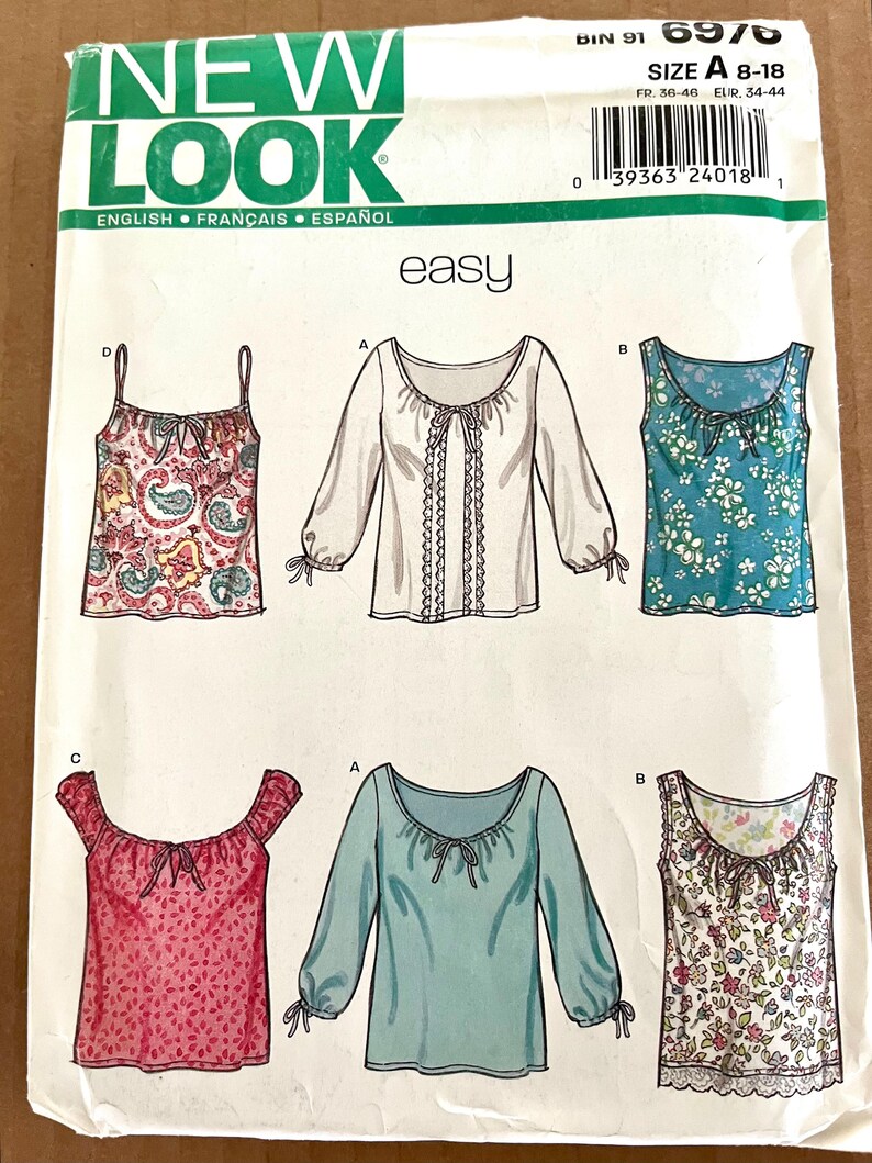 May include: A New Look sewing pattern featuring various blouse designs. The pattern includes illustrations of tops with different sleeve lengths, necklines, and prints. The size range is A 8-18.