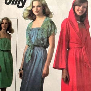 May include: Three women's dress patterns with different styles. The first dress is green and strapless. The second dress is blue with a floral print top and a tie at the waist. The third dress is red with a long sleeve and a hood.