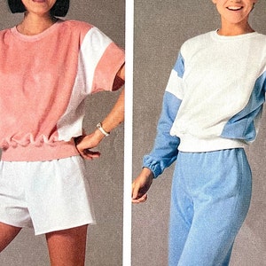 May include: Two women wearing matching athletic outfits. The woman on the left is wearing a pink and white short-sleeved shirt with white shorts. The woman on the right is wearing a white and blue long-sleeved shirt with blue pants.