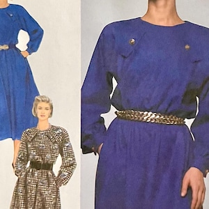 May include: Two blue dresses with long sleeves and a round neckline. The dress on the left has a gold belt and the dress on the right has a gold chain belt.