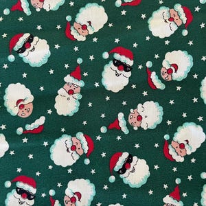 43&quot; wide x 1 yard long lightweight cotton or cotton blend novelty fabric, Santa heads on dark green background, excellent condition.