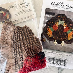 Puede incluir: Un kit de manualidades y un patrón para una decoración otoñal con temática de pavo. El kit incluye flecos, botones y otros accesorios. El patrón tiene un tamaño final de 63.5 cm y es de Happy Hollow Designs.