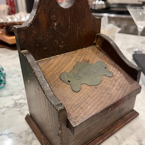 Primitive wooden salt box with hinged lid, metal plate with salt written on it, hangar on back, some expected wear, slight damage.
