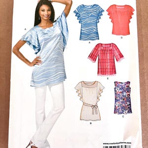 May include: A New Look sewing pattern featuring various women's top designs. The pattern includes a tunic with wave-like patterns, a red plaid top, and other styles. The model is wearing a blue tunic with white pants.