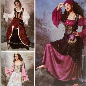 Può includere: Immagine di tre abiti in stile medievale. Uno è rosso e nero con rifiniture bianche, un altro è viola scuro con corpetto dorato, e il terzo è rosa e bianco con dettagli dorati. Gli abiti sono esposti su uno sfondo chiaro.
