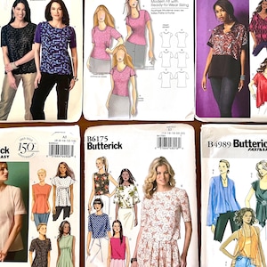May include: A collection of sewing pattern envelopes featuring various women's tops and blouses. The patterns include different styles, such as short-sleeved, long-sleeved, and sleeveless designs, with a range of necklines and details. The envelopes display images of the finished garments.
