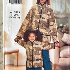 May include: A sewing pattern for a teddy bear print jacket and matching child's jacket. The pattern includes all sizes in one envelope. The adult jacket has a mandarin collar and long sleeves. The child's jacket has a similar design with a shorter length.